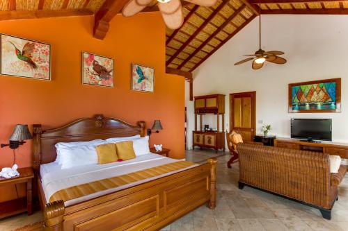 霍普金斯The Colonial at Jaguar Reef的一间卧室配有一张橙色墙壁的床