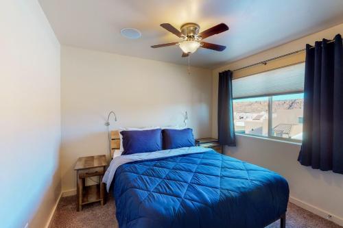 摩押Rim Vista 11A2的一间卧室配有蓝色的床和吊扇