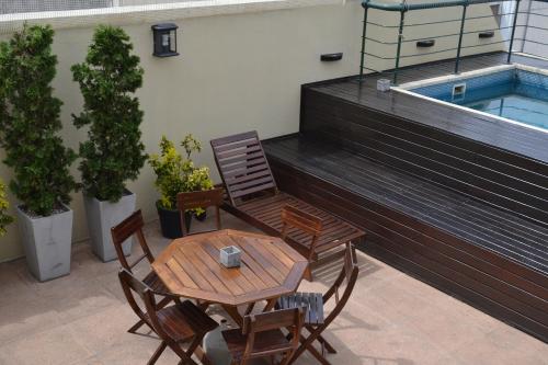 布宜诺斯艾利斯皮卡路加公寓酒店的一个带桌椅的庭院和一个游泳池