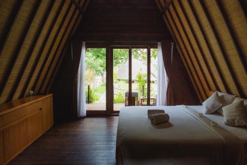 珀尼达岛Batan Sabo & Co的一间卧室设有一张床和一个大窗户