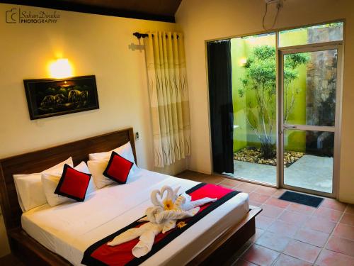达瓦拉维汉塔拉乌达瓦拉瓦酒店的一间卧室配有一张带红色枕头的床和一扇窗户
