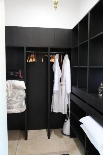 TerranoraJodha Bai Retreat的黑色衣柜,配有黑色橱柜和白色衣服