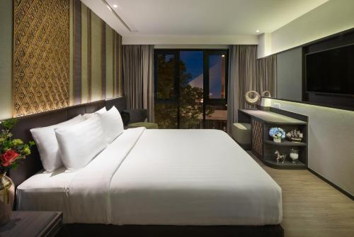 曼谷Chillax Heritage Hotel Khaosan - SHA Extra Plus的卧室配有一张白色大床和电视。