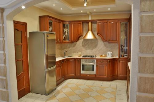 圣彼得堡Apartment Nevskaya Classica的厨房配有木制橱柜和不锈钢冰箱。