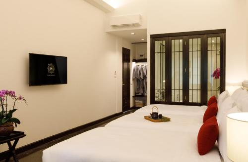 清迈Aksara Heritage -SHA Extra Plus的卧室配有白色的床,并有手表