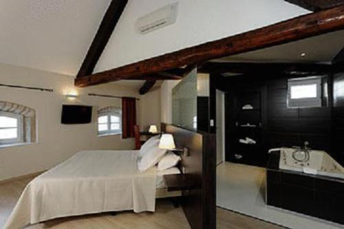 桑畔斯蒙特乔利城堡酒店的一间卧室配有一张床,浴室设有水槽