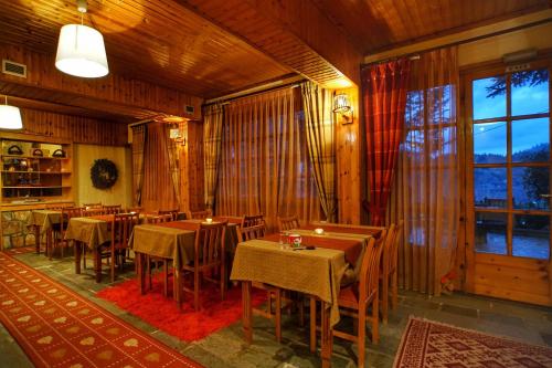 埃普塔罗弗斯Guesthouse Alexandra的餐厅设有桌椅和大窗户。