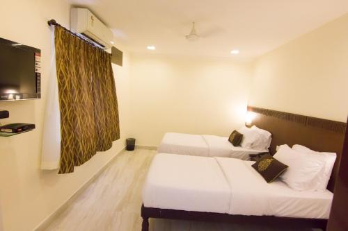 钦奈九霄云外服务式公寓式酒店的酒店客房设有两张床和电视。
