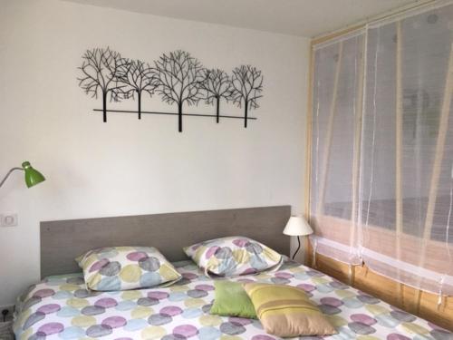 梅斯高尔夫花园公寓的卧室配有一张墙上树木环绕的床