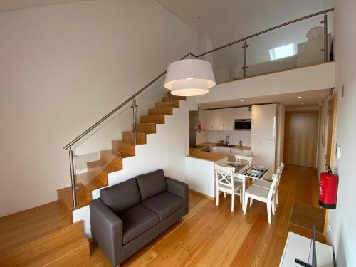 英雄港Casa dos Remedios的客厅以及带沙发和楼梯的厨房。