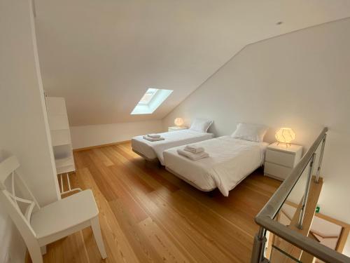 英雄港Casa dos Remedios的白色卧室配有两张床和椅子