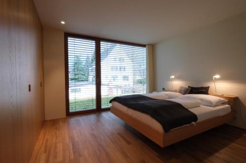 卢斯特瑙Ferienhaus S11 Lustenau的一间卧室设有一张大床和一个大窗户