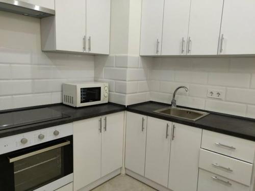 敖德萨1-к кв ж/м Радужный的白色的厨房配有微波炉和水槽