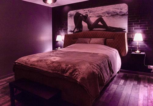 埃夫勒Suite avec Jacuzzi et Sauna Privée的卧室配有一张床,卧室内有一个人躺在床上