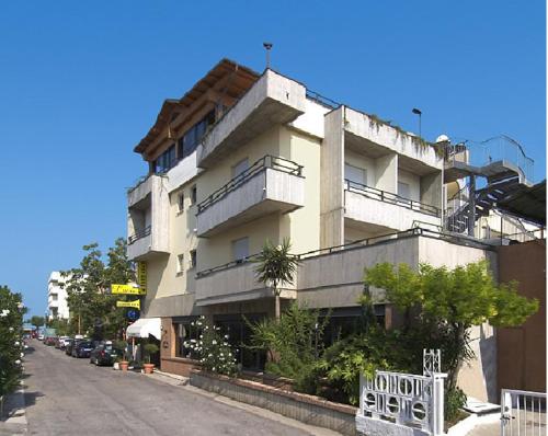 朱利亚诺瓦Ristorante Hotel Lucia - 100 mt dal mare的街道边带阳台的大型建筑