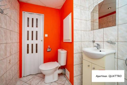 索科洛夫Apartman QUATTRO的橙色浴室设有卫生间和水槽