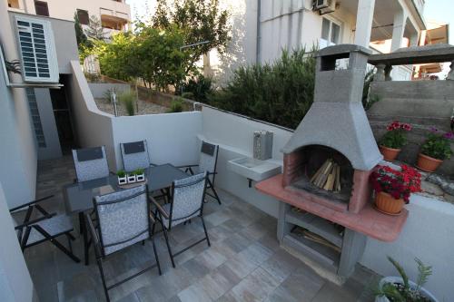 奇茲希Apartments Klaudija的庭院设有壁炉和桌椅。