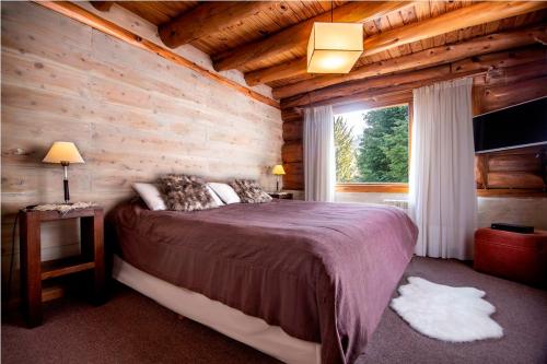 圣卡洛斯-德巴里洛切苏德布鲁克旅馆的小木屋内一间卧室,配有一张大床