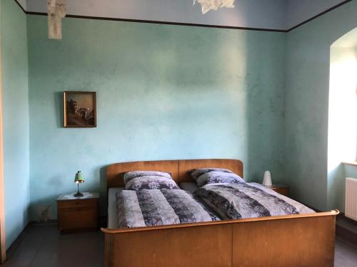 安娜贝格-布赫霍尔茨Wolke 33的卧室内的一张床铺,卧室内有蓝色的墙壁