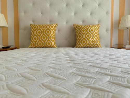 纳扎雷Duarte Houses T2 - com vista mar的卧室配有一张带两个枕头的大白色床