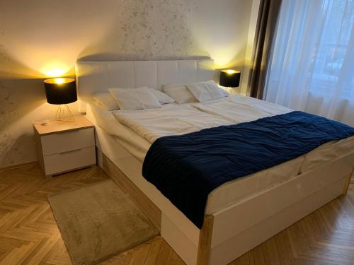 米什科尔茨W19 Apartments的卧室内的一张大床,配有两盏灯