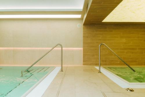 霍德梅泽瓦沙海伊金客阁酒店的一座大楼内带热水浴池的游泳池