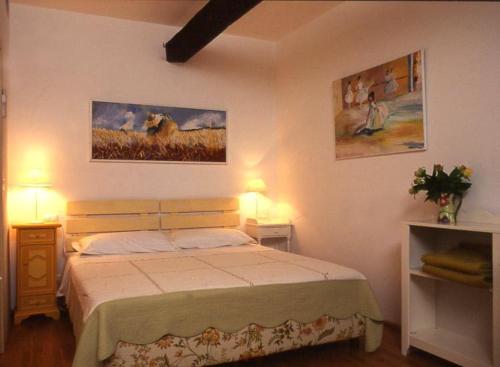 多尔切阿夸Agriturismo La Vecchia Dolceacqua的卧室配有一张床,墙上挂有两张照片