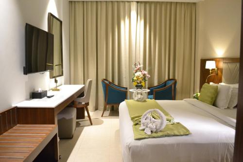 麦纳麦拉米皇宫酒店的配有一张床和一张书桌的酒店客房
