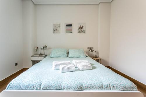 拉科鲁尼亚APARTAMENTO EN PRIMERA LINEA DE PLAYA RiAZOR的白色卧室配有带2个枕头的床