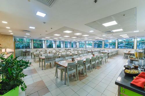 特拉维夫HI - 贝内丹- 特拉维夫旅舍的用餐室设有桌椅和窗户。
