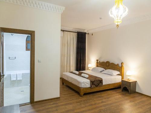 布哈拉Royal Bukhara hotel的一间卧室配有一张床和一个吊灯