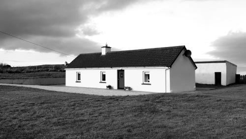 多尼戈尔Granny Dens的白色的房子,前面有一只狗
