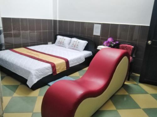 芹苴Kiến An Hotel Cần Thơ的一间卧室配有两张床和红色椅子