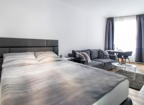 萨格勒布Main Square Modern Apartments的一间卧室配有一张大床和一张沙发
