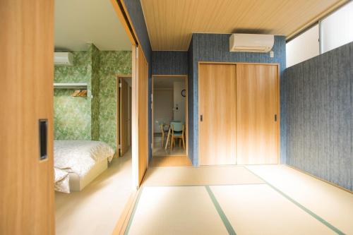 大阪guest house Sora的一间设有床铺的房间和通往卧室的门