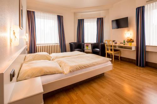 亚琛Hotel Buschhausen的配有一张床和一张书桌的酒店客房