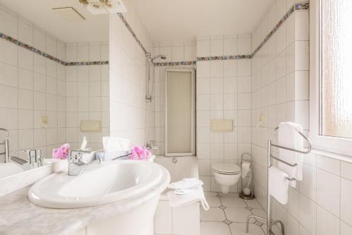 亚琛Hotel Buschhausen的白色的浴室设有水槽和卫生间。