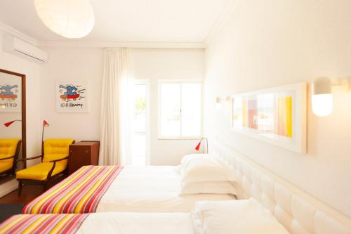 蒙蒂戈杜瓦斯科达伽马酒店的酒店客房,设有两张床和一张黄色椅子