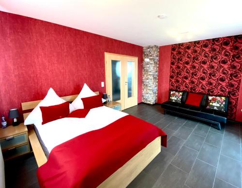 胡根尔舍姆Apartment的红色卧室设有一张大床和一个壁炉