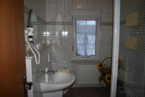 艾森纳赫Pension zur Krone的一间带水槽和卫生间的浴室以及窗户。