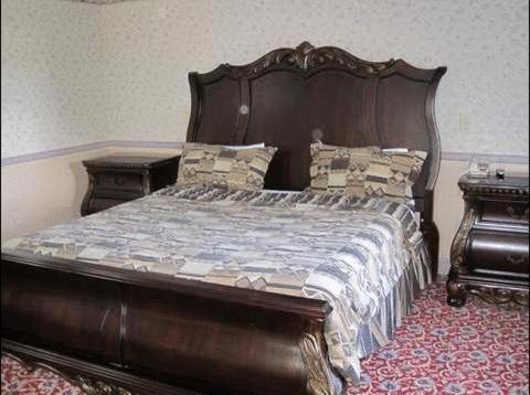 莫里斯普莱恩斯帕西帕尼套房酒店 的一间卧室配有木床和两张桌子
