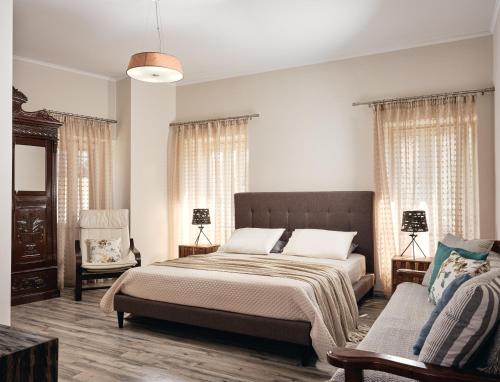 Agios LeonJoya Village House的一间卧室配有一张大床和一张沙发