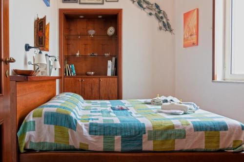 那不勒斯A wonderful penthouse in Naples的一间卧室配有一张床和一个木制橱柜