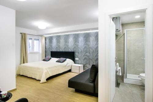 杜布罗夫尼克Dubrovnik Spectrum Rooms的一间卧室配有一张床、一张沙发和一个卫生间