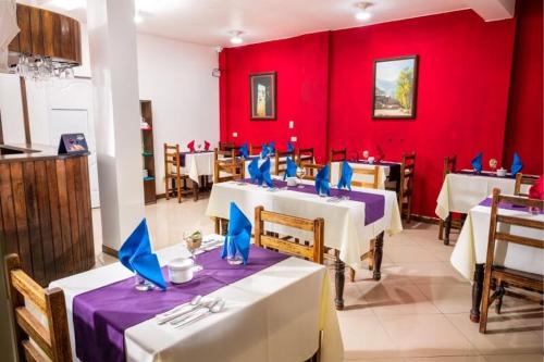 奇瓦伊La Casa de Anita的一间设有两张桌子和红色墙壁的餐厅
