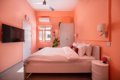 特拉维夫Glamorous Pink Pearl Studio/Beach/Parking/Netflix的一间卧室设有橙色的墙壁和一张带泰迪熊的床。
