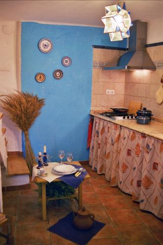 莱图尔Casa Rural Albayacín的厨房配有桌子和蓝色的墙壁