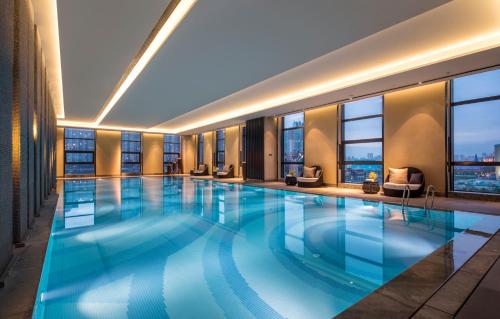 哈尔滨哈尔滨松北融创皇冠假日酒店的一座带窗户的大型游泳池