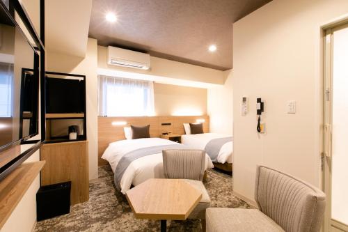 札幌Hotel Wing International Sapporo Susukino的酒店客房设有两张床和电视。