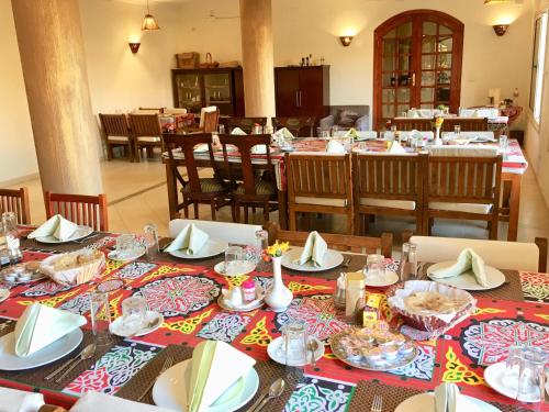 卢克索新门农酒店的一间用餐室,配有带盘子和盘子的桌子